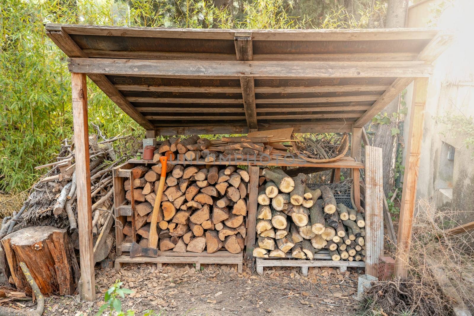 Organized woodshed prepared to use the wood in the fireplace inside the house in winter. by PaulCarr