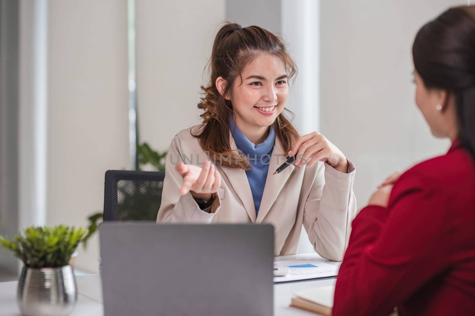 Two business women are discussing and exchanging knowledge on graphs and finance data..