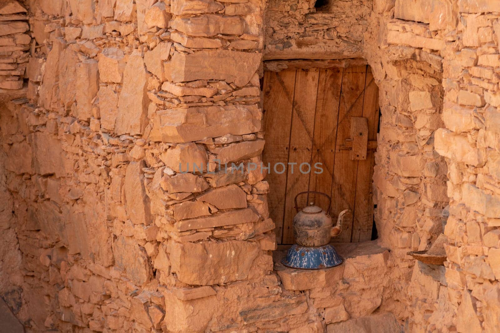 An old tea can in front of an antique window shutter of a berber house in Morocco