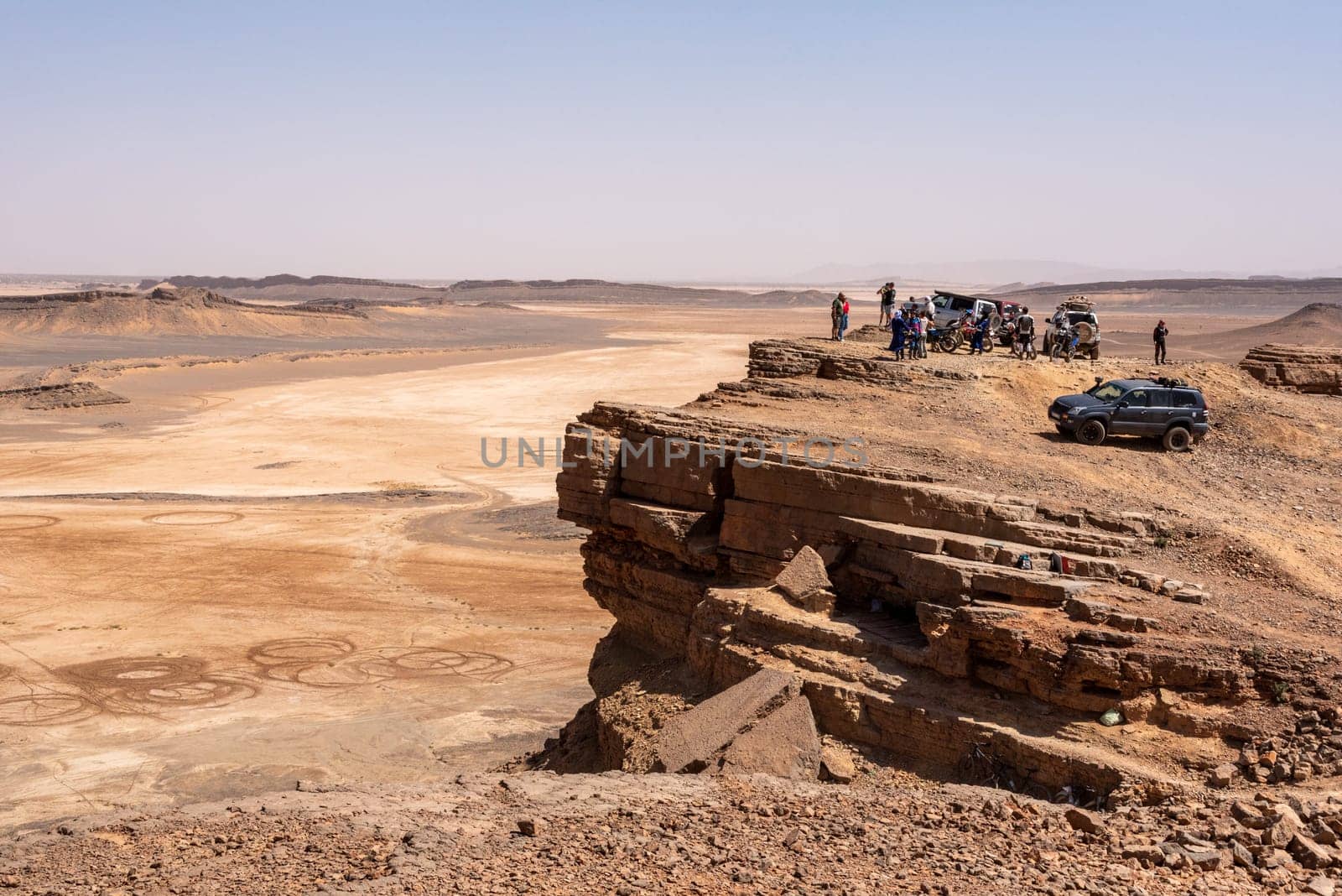 Tourists enjoying the scenic view of the Sahara desert from mount Gara Medouar, Morocco