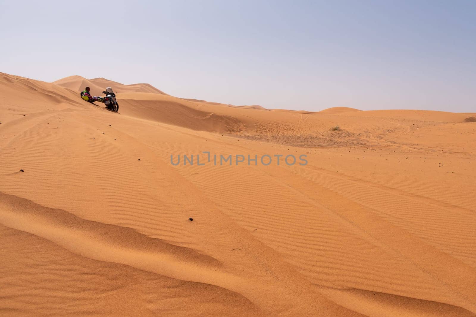 A motorbiker driving off-road in the Erg Chebbi desert became stuck in the sand, Morocco