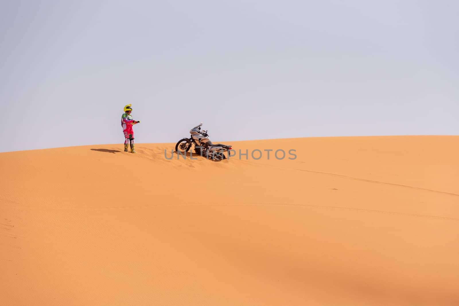 A motorbiker driving off-road in the Erg Chebbi desert became stuck in the sand by imagoDens