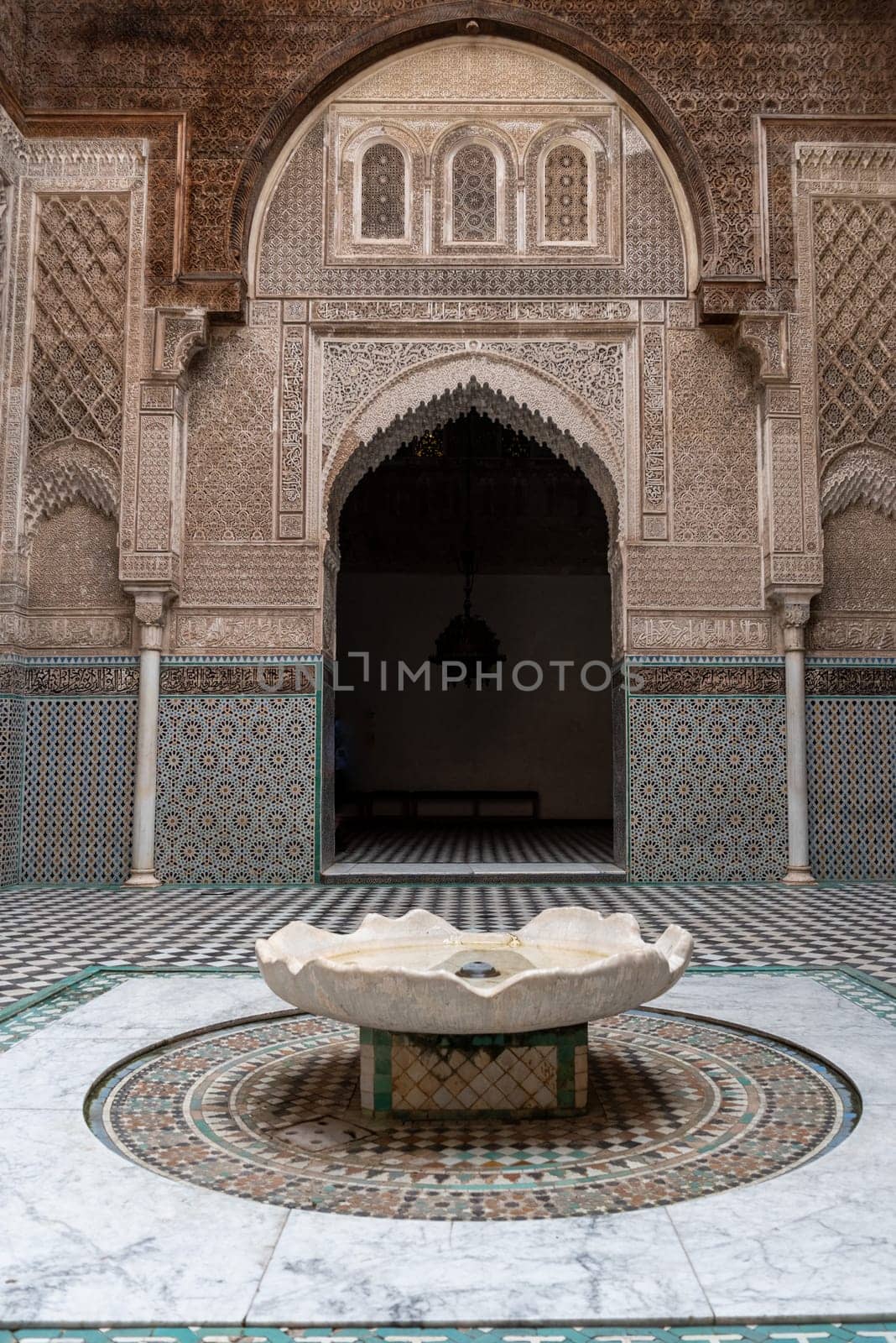 Fes, Morocco - April 04, 2023 - Rich decorated facade in the courtyard of the Medersa Attarine in Fes by imagoDens