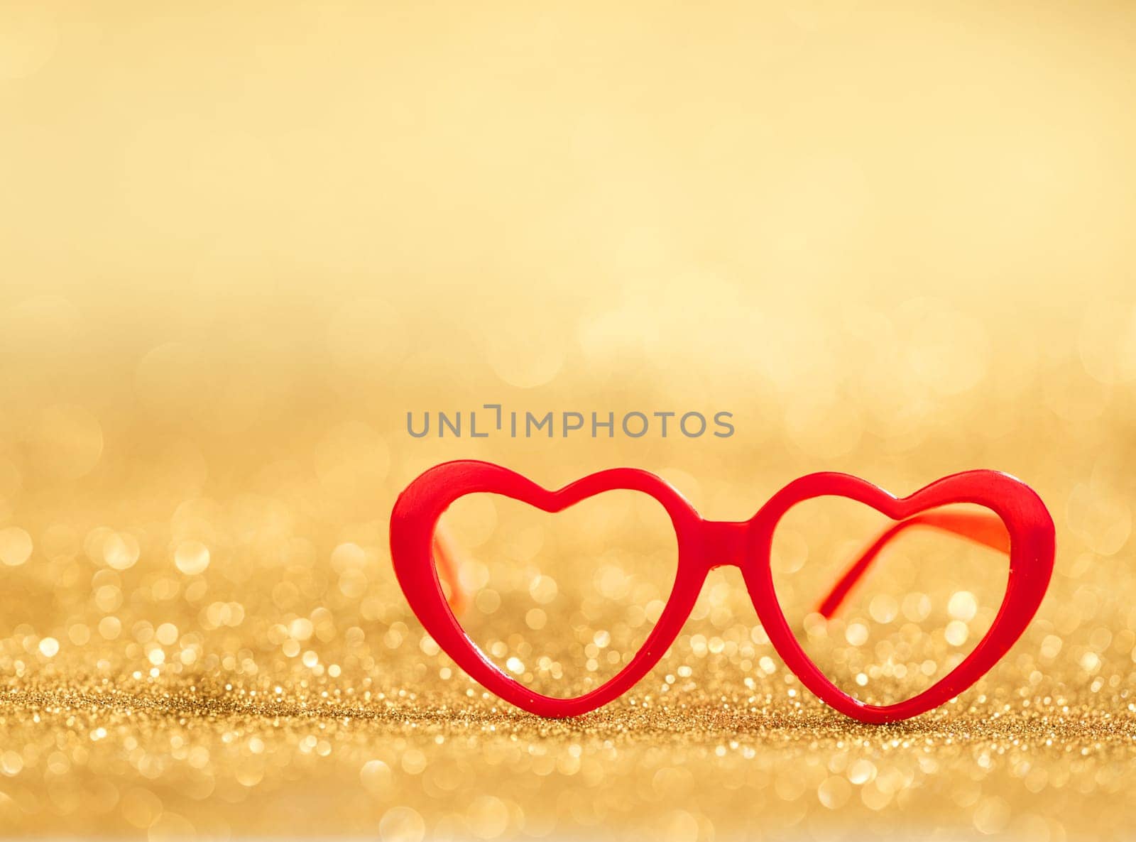 red hearts glasses on golden bokeh background