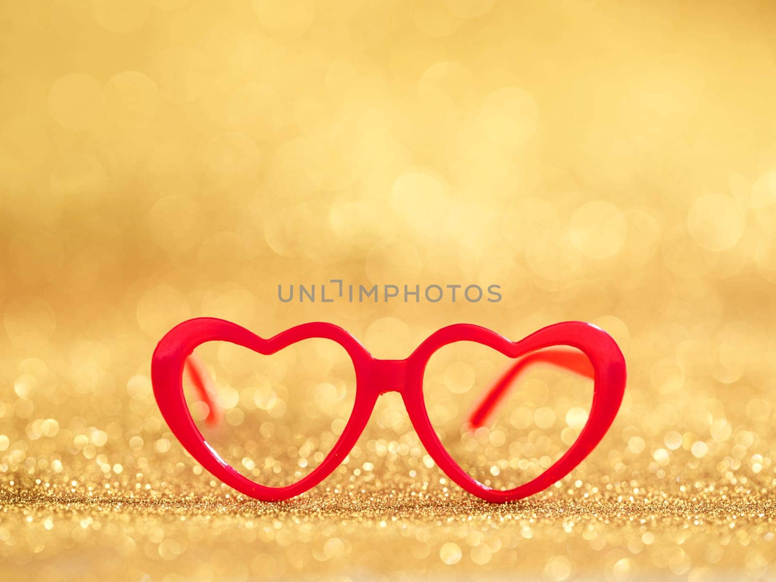 red hearts glasses on golden bokeh background