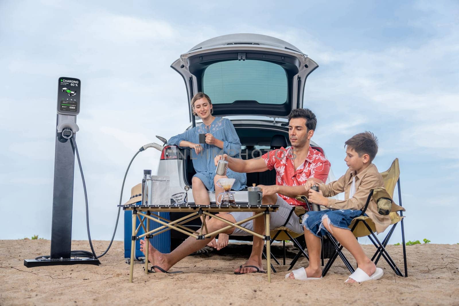 Family vacation trip traveling by the beach with electric car, happy family recharge EV car, enjoying outdoor camping coffee. Seascape travel and eco-friendly car for clean environment. Perpetual