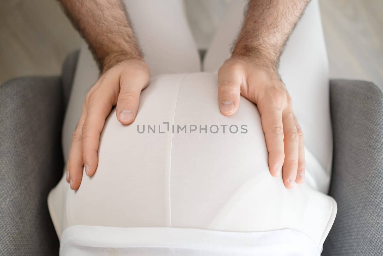 Man hands lovely touches pregnant womans belly, top view