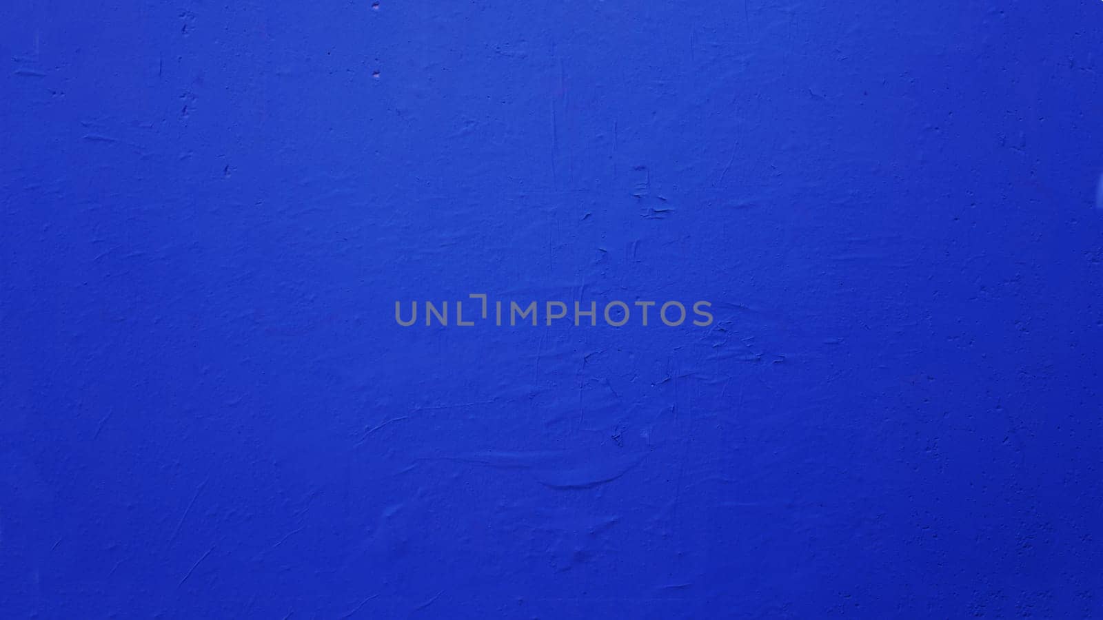 Texture of a concrete wall painted in rich blue color. Grunge cement wall color blue.