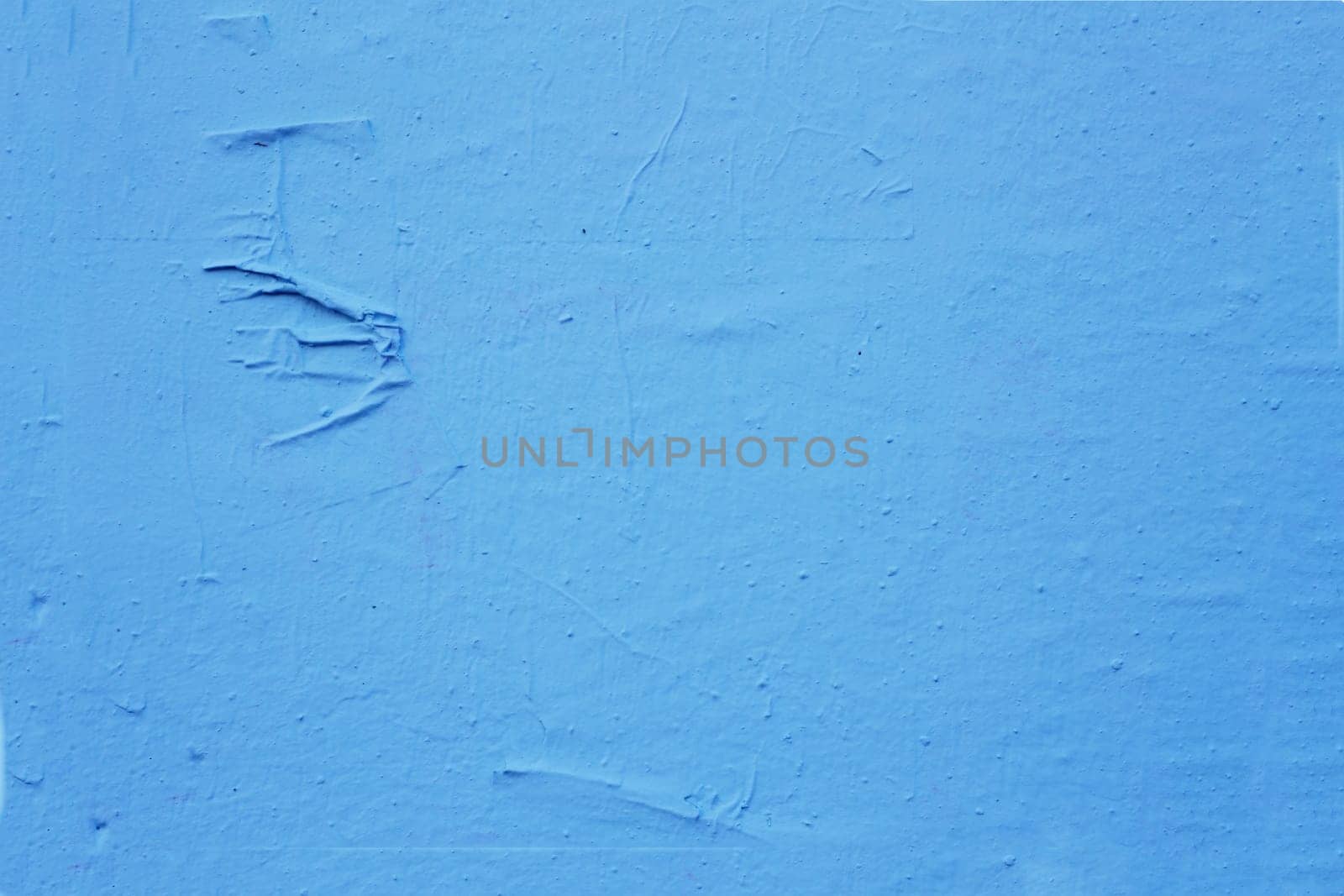 Old, time-damaged blue paint on the wall. Grunge cement wall color blue.