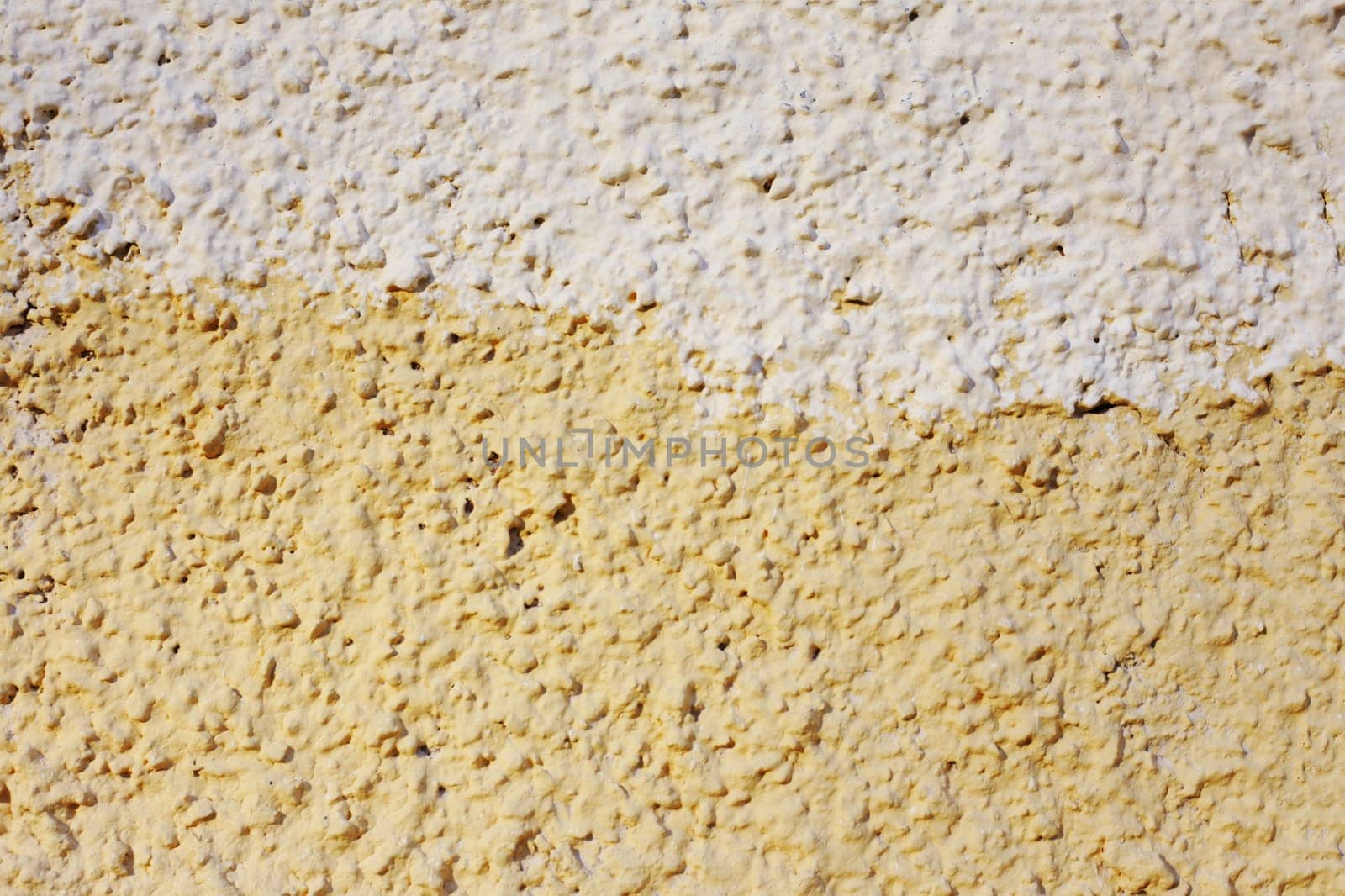 Abstract background of orange and beige paint on the wall close-up. The fong is half painted in different colors.