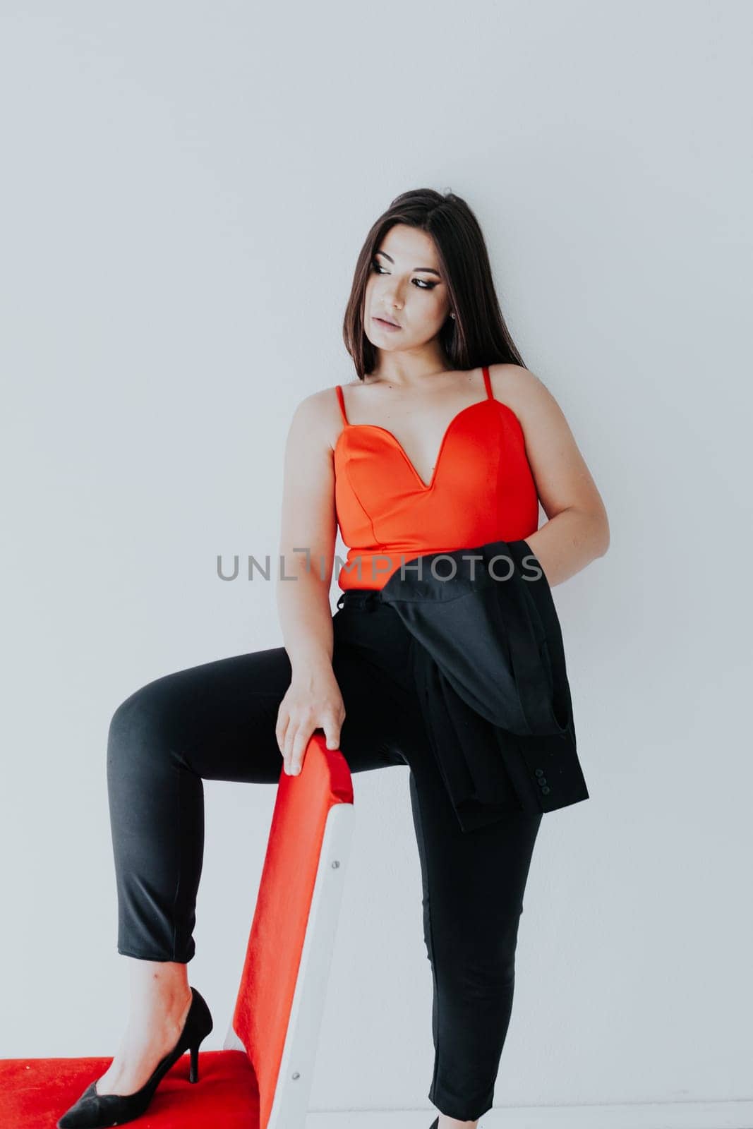 Beautiful fashionable Armenian woman in red black business suit