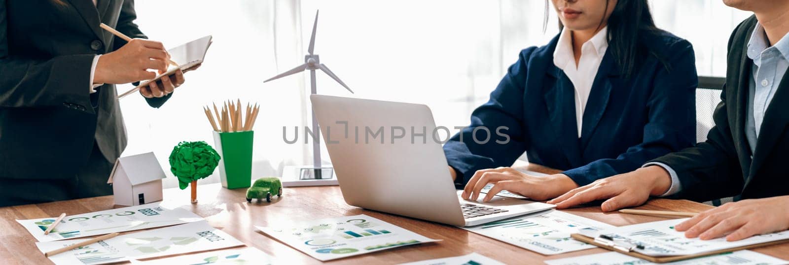 Eco business company meeting with group of business people using laptop to plan strategy and discuss marketing of eco-friendly and clean energy products. Green business company concept. Trailblazing