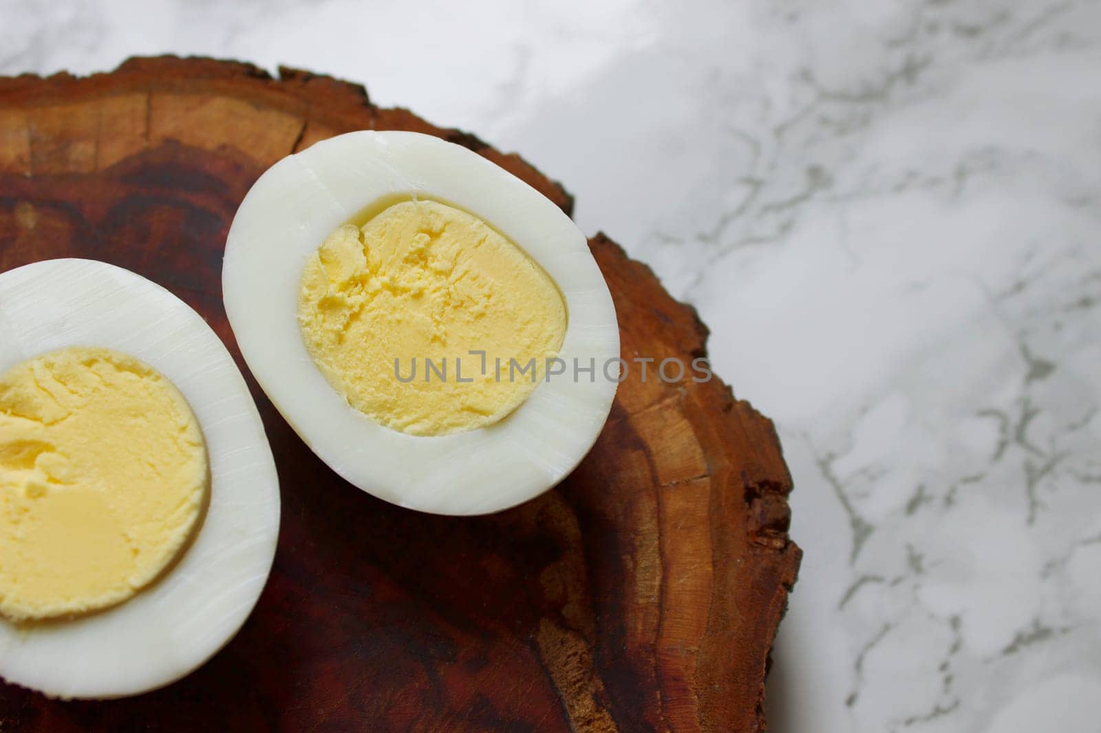 Boiled chicken egg on a wooden board on a marble background. High quality photo