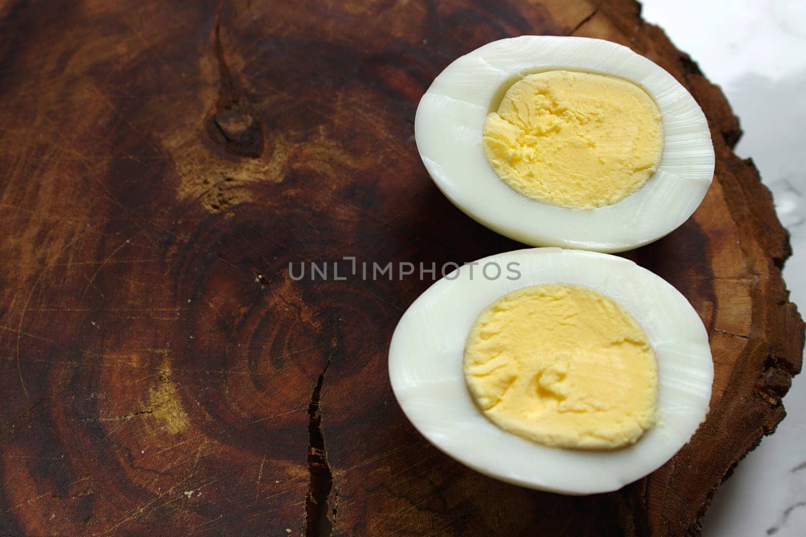 Boiled chicken egg on a wooden board on a marble background. High quality photo