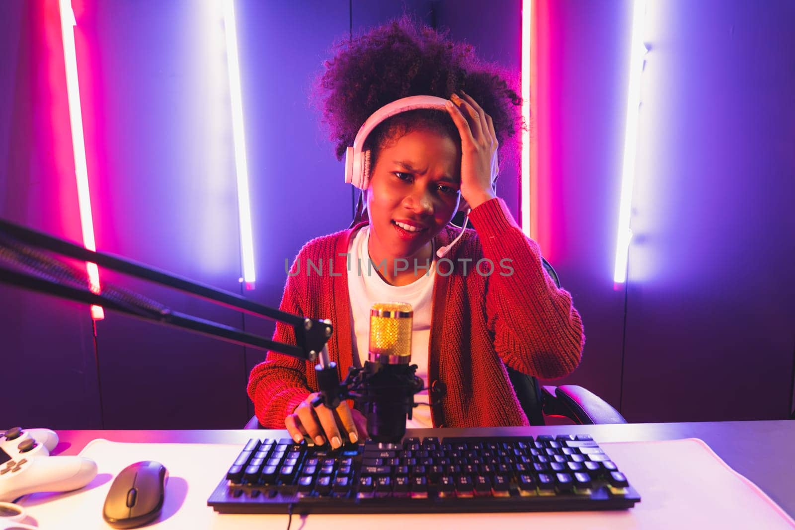 Host channel of gaming streamer, African girl taking, typing with Esport skilled team player and viewers online game in neon color lighting room. Concept of cybersport indoor activities. Tastemaker.