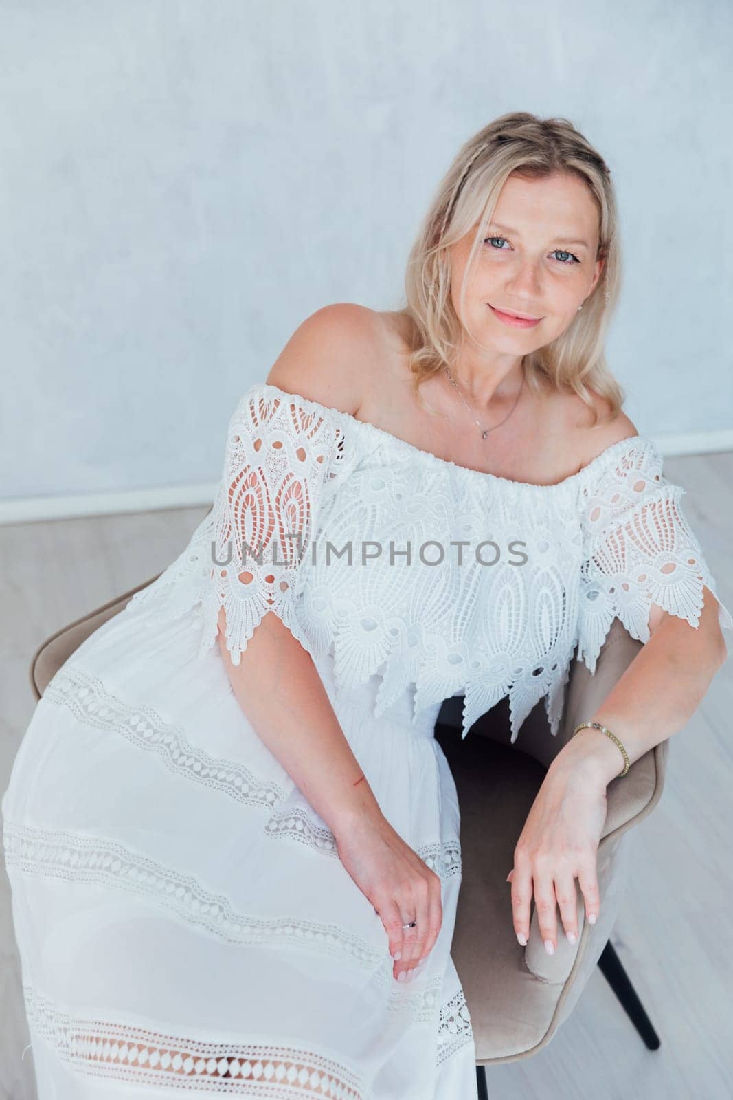 Portrait of a beautiful young slender woman in a white summer knitted dress by Simakov