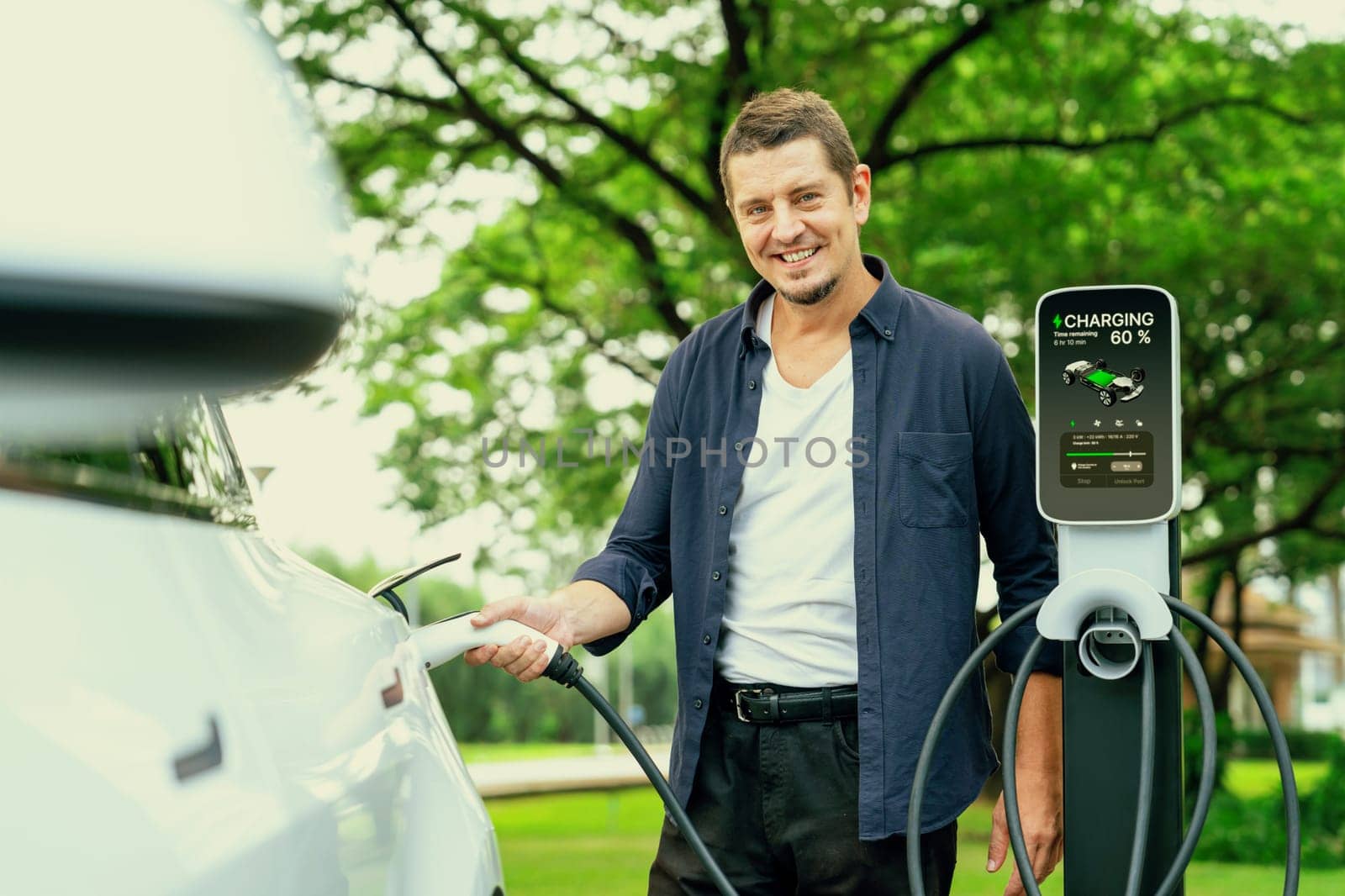 Man recharge EV electric vehicle battery from EV charging station. Exalt by biancoblue