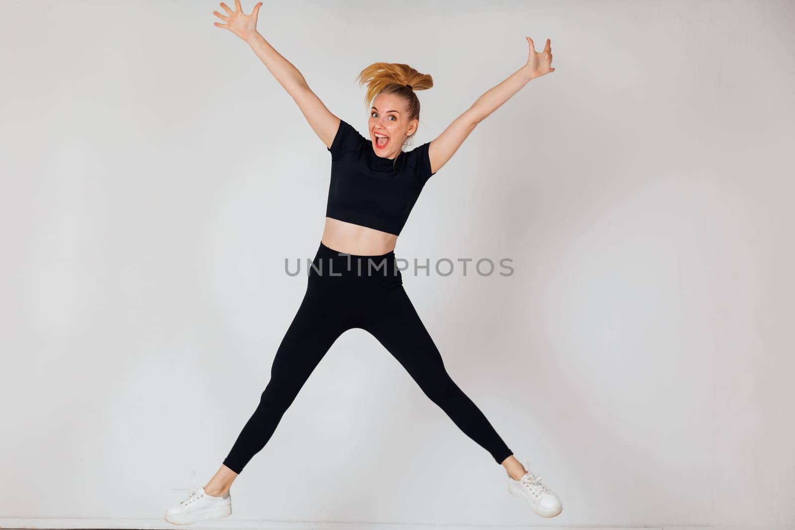 a woman jumps doing exercise warm-up exercises in the gym