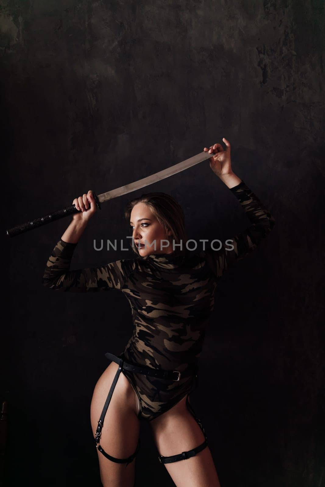 military woman with a sword on a black background in a dark room by Simakov