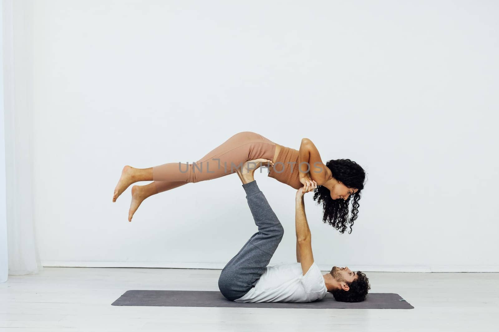 a woman and man practice yoga lotus pose stretching healthy back asana exercises
