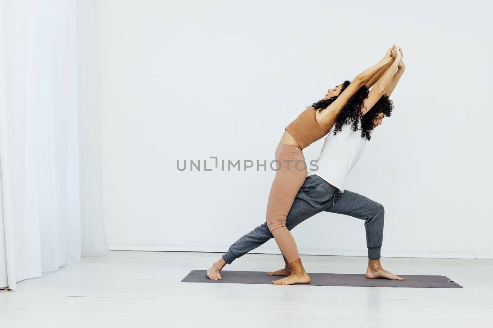 woman and man practice yoga lotus pose stretching healthy back asana exercises by Simakov