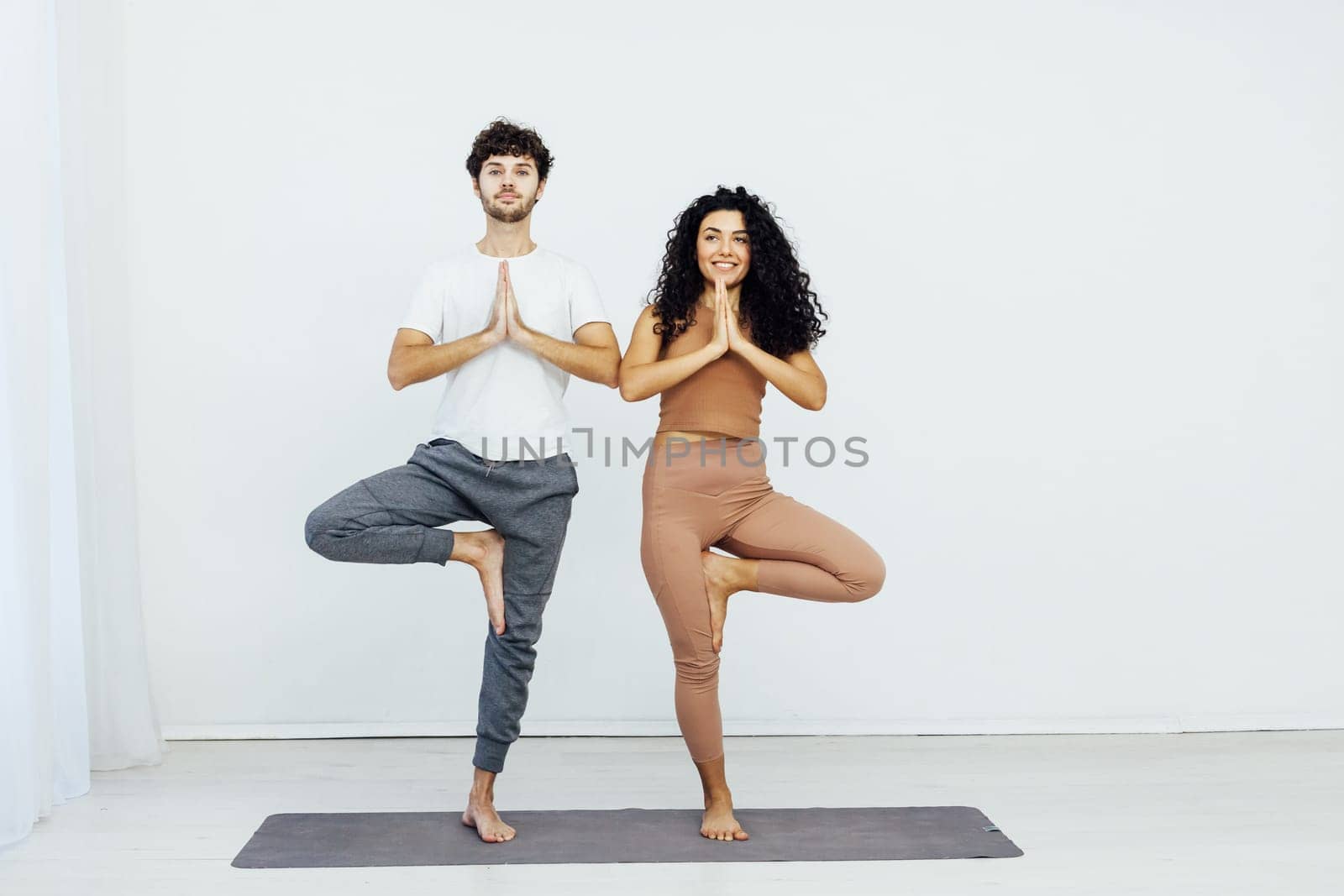 woman and man practice yoga lotus pose stretching healthy back asana exercises by Simakov