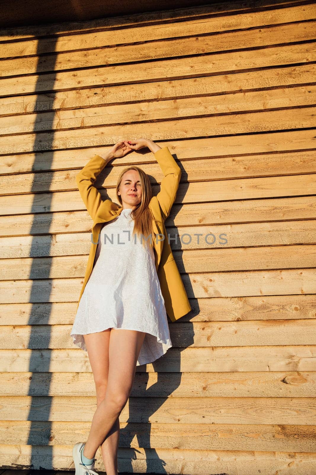 blonde woman in a light summer dress and yellow jacket by Simakov