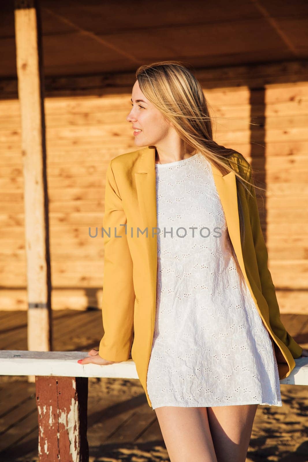 blonde woman in a light summer dress and yellow jacket by Simakov