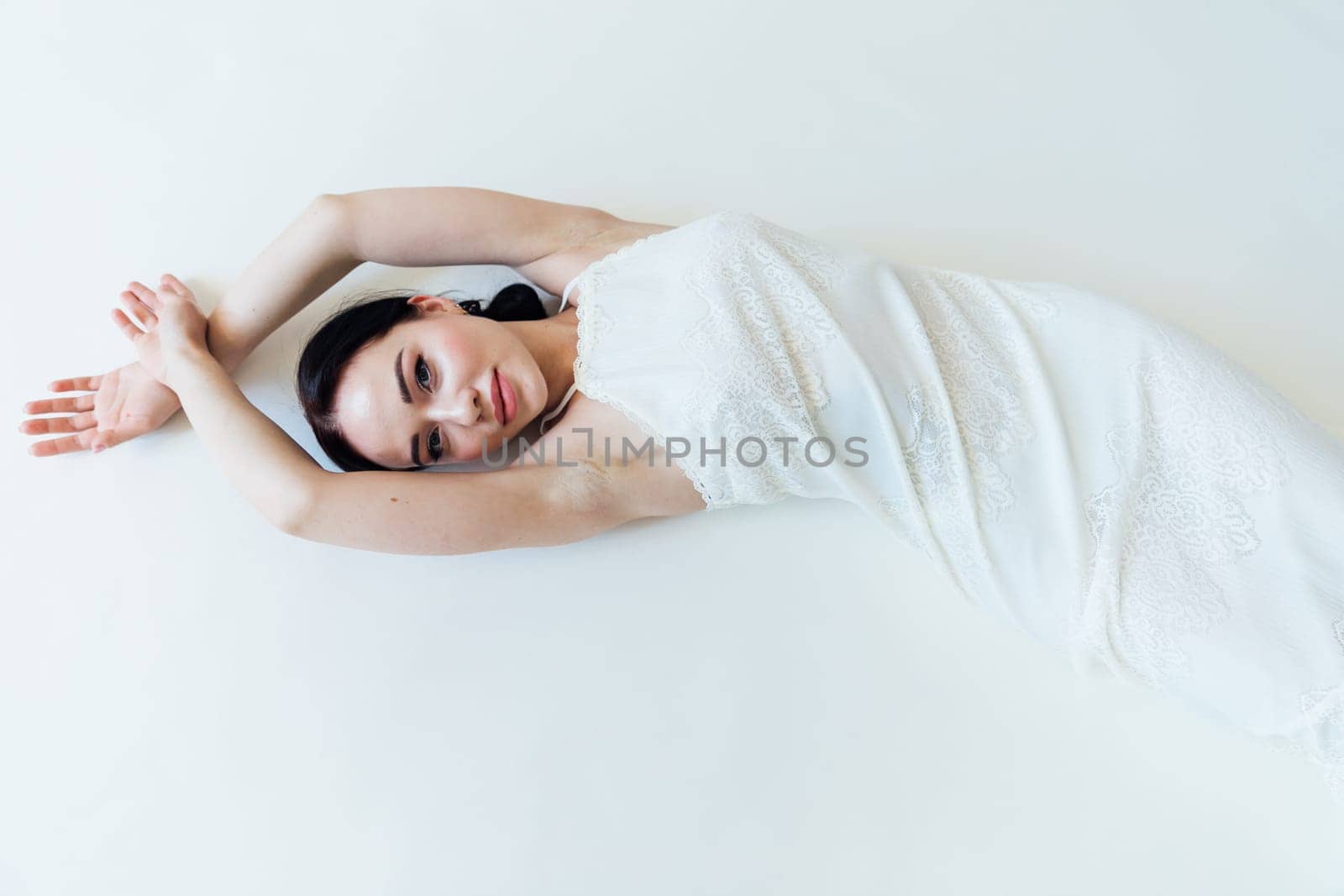 beautiful brunette woman in a white wedding dress by Simakov