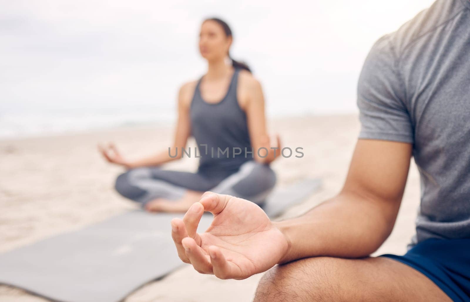 People, lotus hands and beach meditation for zen fitness, calm exercise and mindfulness or holistic wellness. Yoga class outdoor with person in meditation for peace and mental health by sea or nature.