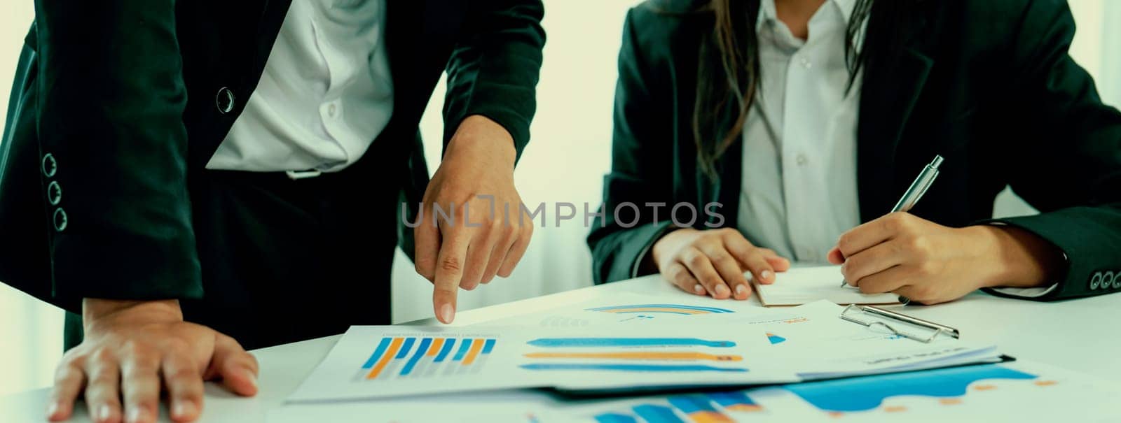 Business people in group meeting in formal attire share idea discussing report for company profit in creative workspace for start up business shot in close up view on group meeting table . Oratory .