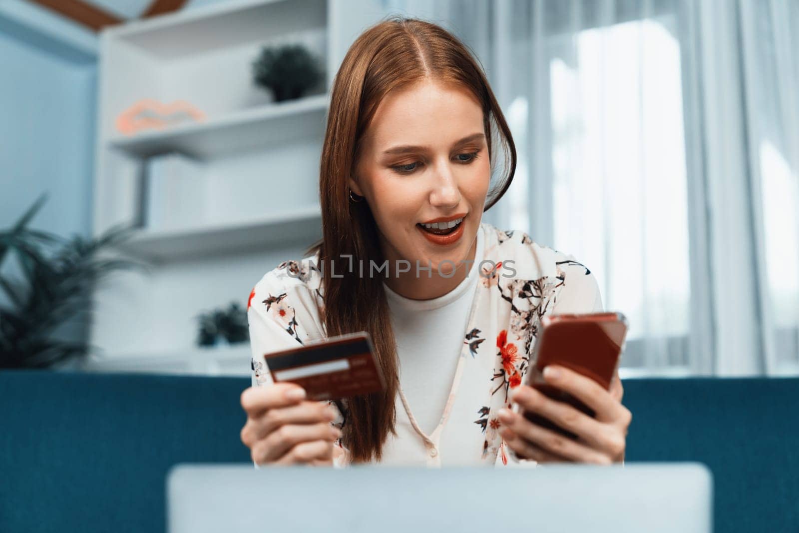 Young happy woman buy product by online shopping at home while ordering items from the internet with credit card online payment system protected by utmost cyber security from online store platform