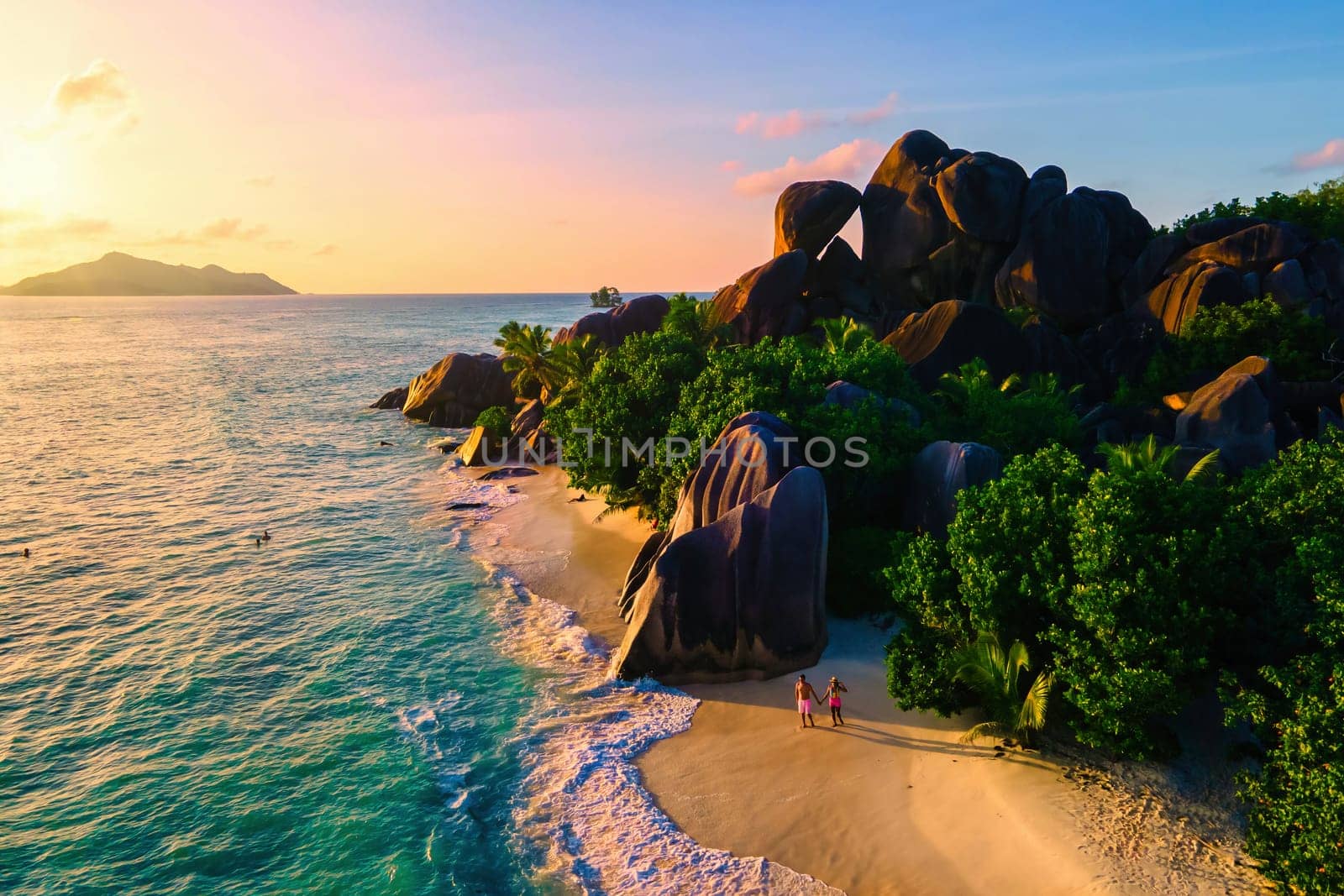 Anse Source d'Argent beach, La Digue Island, Seychelles, Drone aerial view of La Digue Seychelles bird eye view. of tropical Island, couple men and woman walking at the beach at a luxury vacation