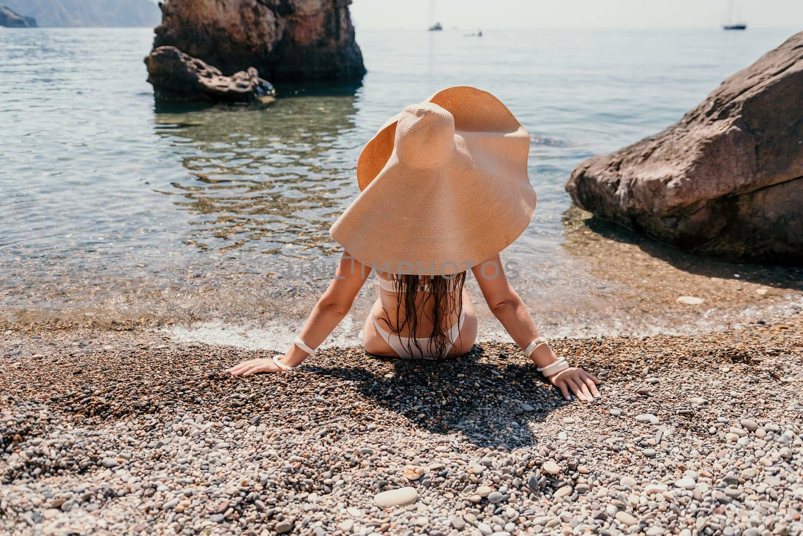 Woman travel sea. Happy tourist in hat enjoy taking picture outdoors for memories. Woman traveler posing on the beach at sea surrounded by volcanic mountains, sharing travel adventure journey by panophotograph