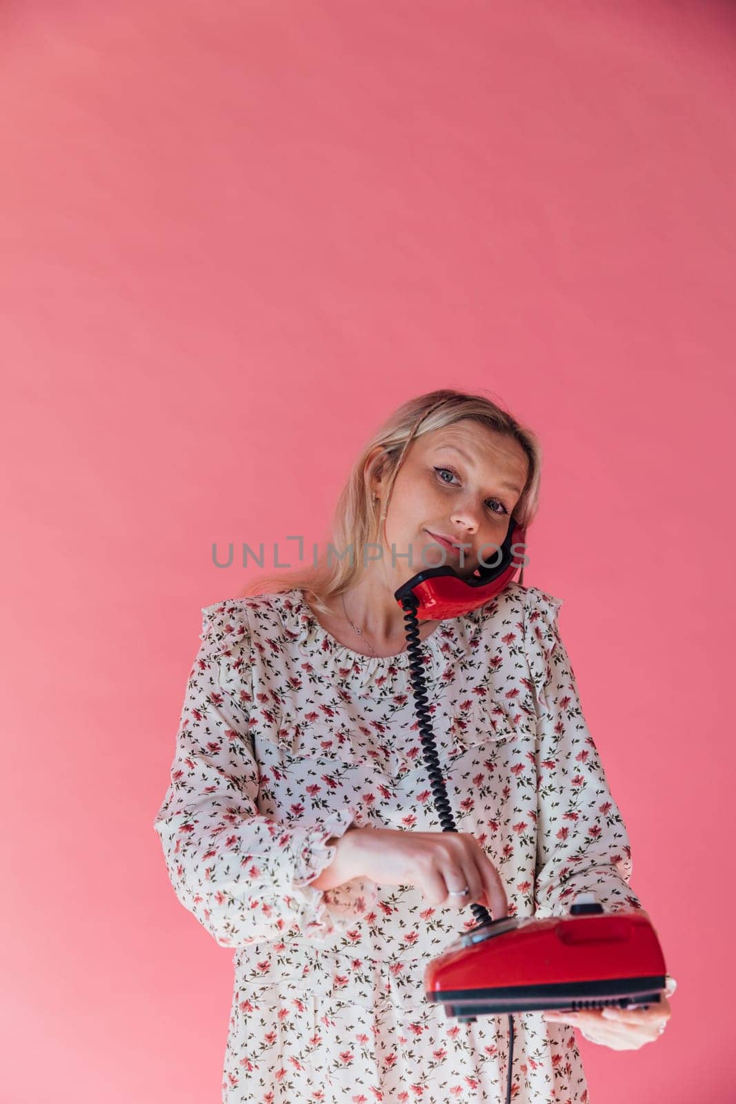 Woman talking on an old wired phone by Simakov