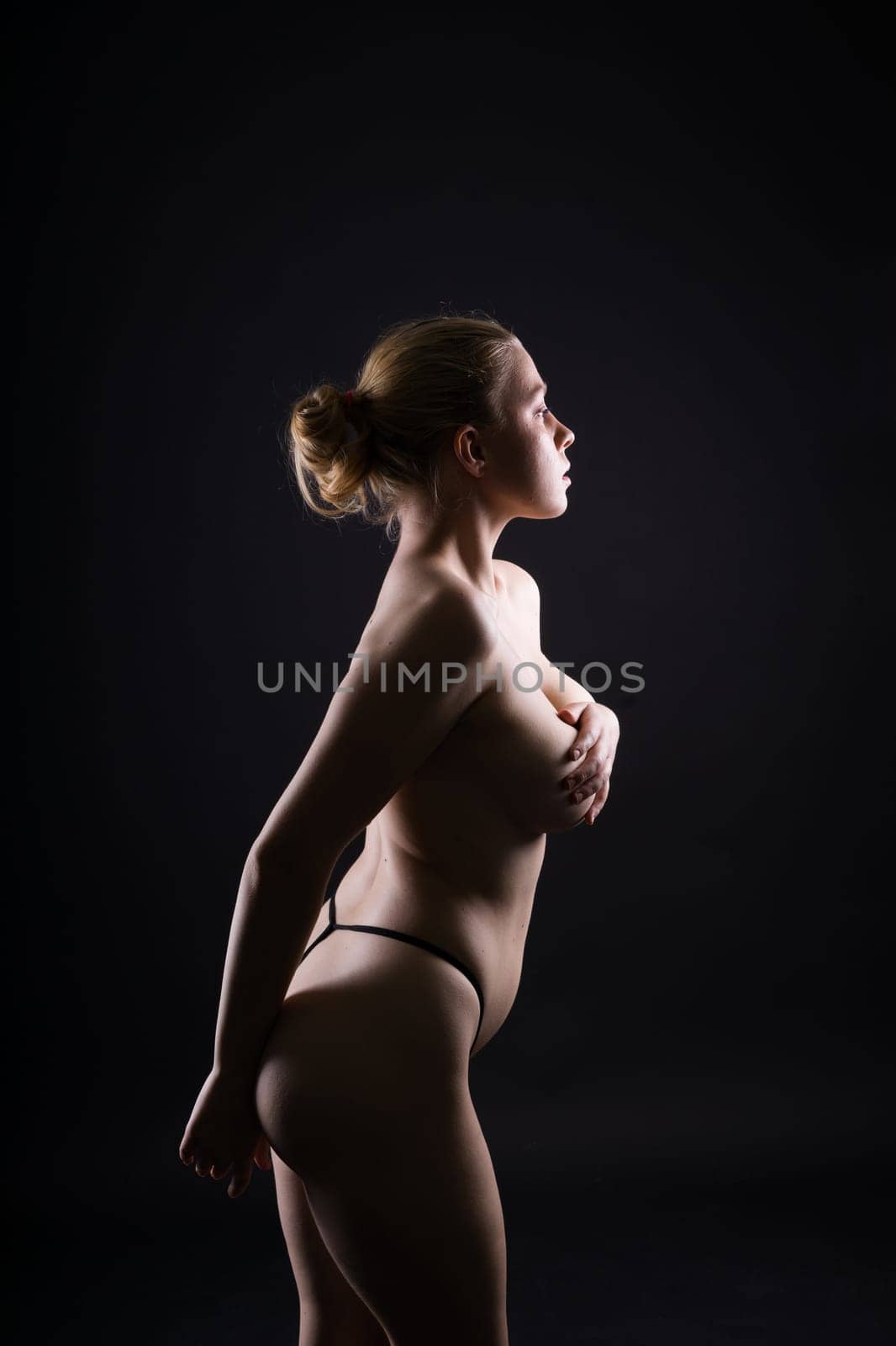 Low key portrait of beautiful female body on a dark background