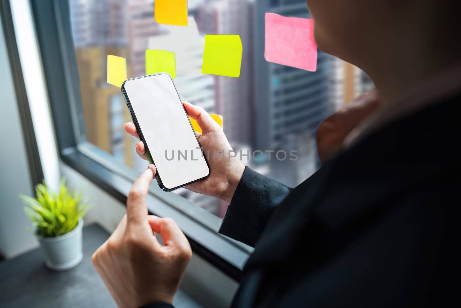 Business woman hand holding using mockup mobile phone with white blank screen for text, mobile app design and advertising, online marketing by nateemee