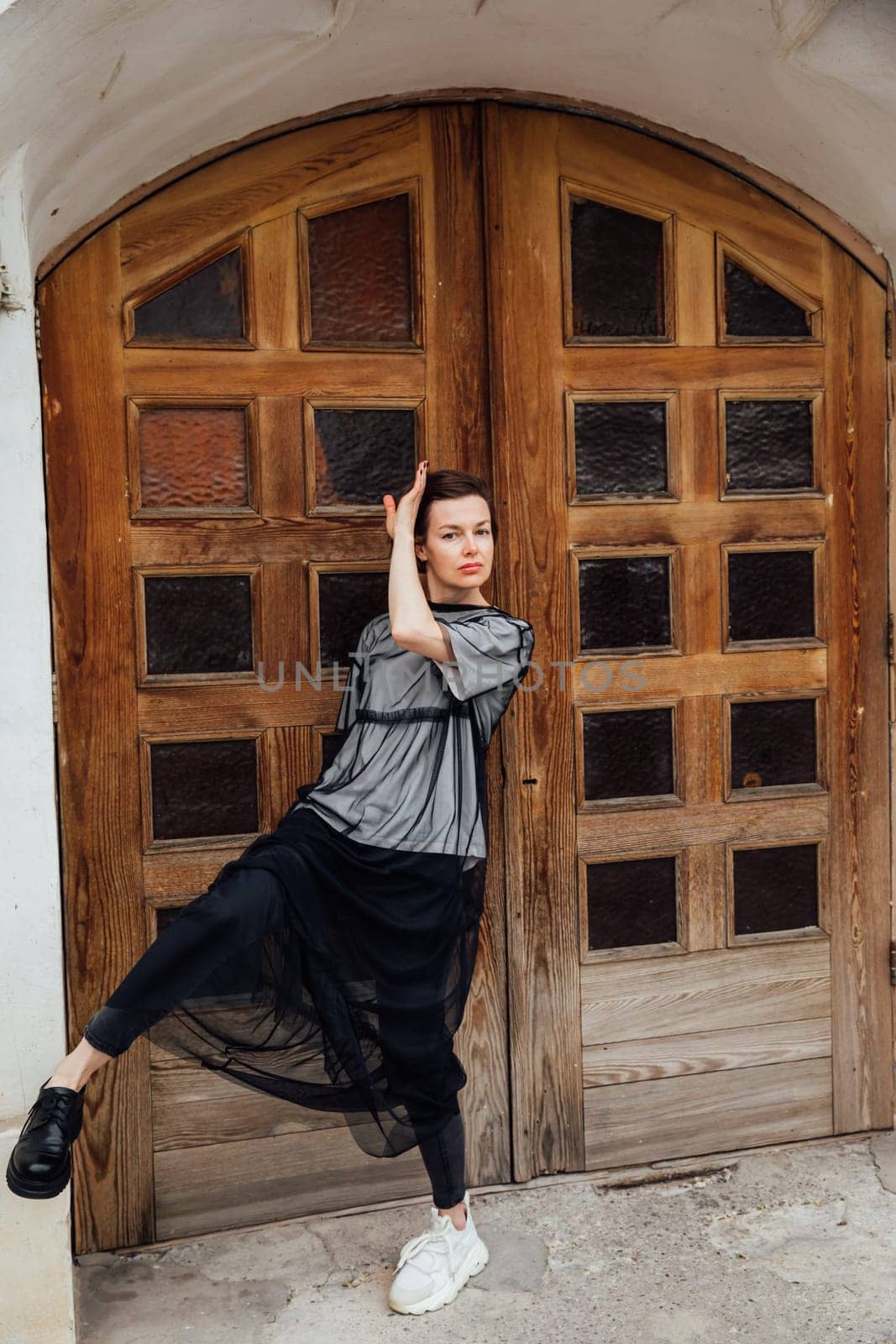 Slender fashionable woman walking outdoors by Simakov