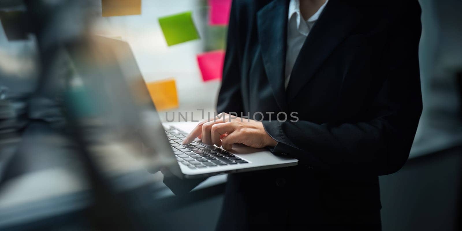 Close up Asian business woman using laptop to calculate tax and financial data of business at office.