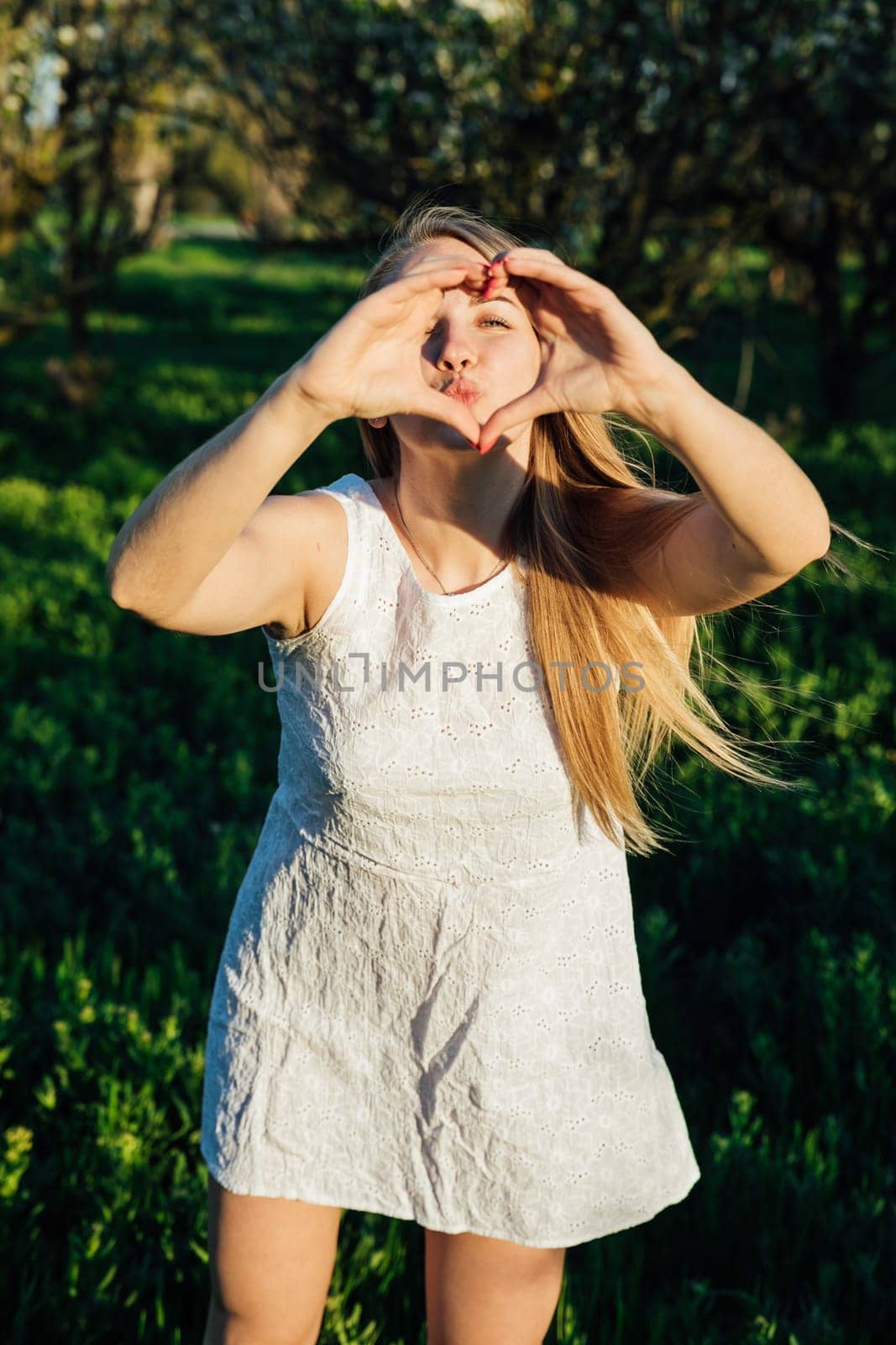 woman shows heart in park walk nature