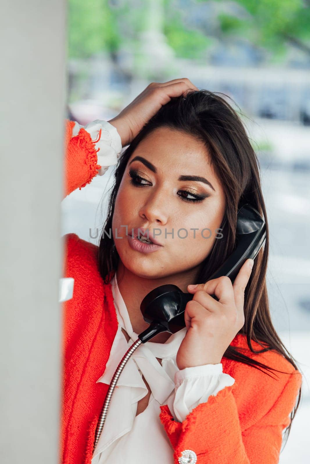 Woman talking on the phone in a booth