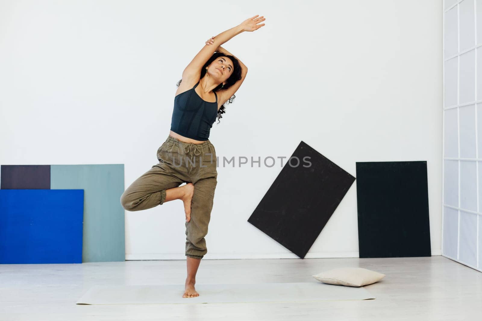 yoga asana woman doing exercises lotus pose workout in studio by Simakov