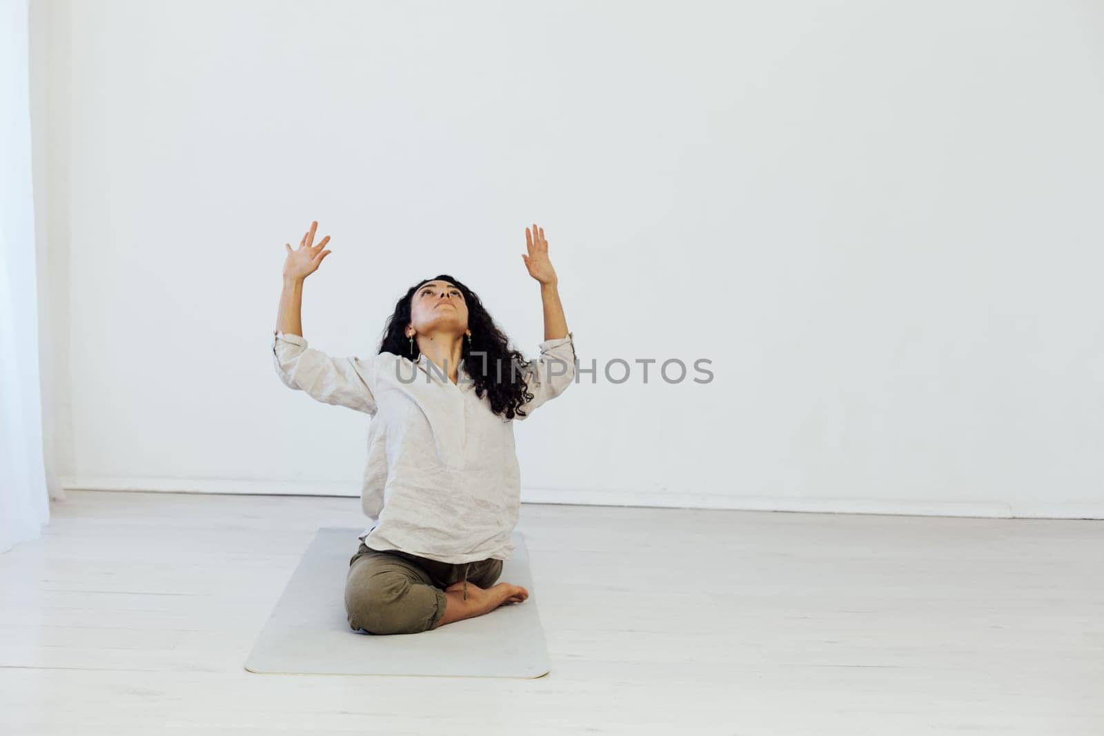 workout in the studio woman doing exercises yoga asana shavasana lotus pose by Simakov