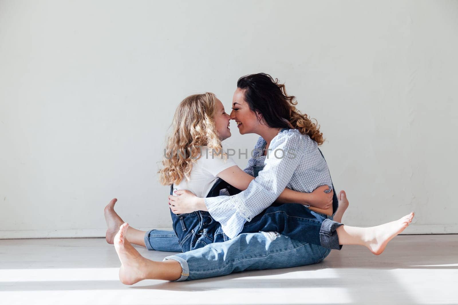 Mother and daughter in a bright room on a white background Family