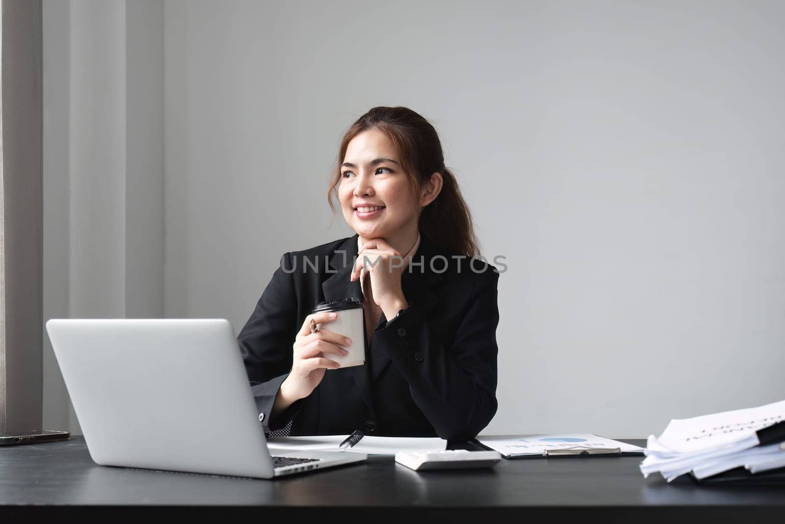 Asian businesswoman sitting in office with confidence.