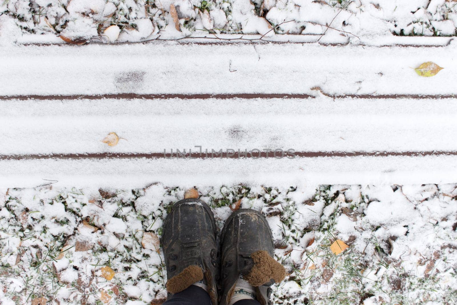 Old shoes on snowy ground in front of straight lines. High quality photo