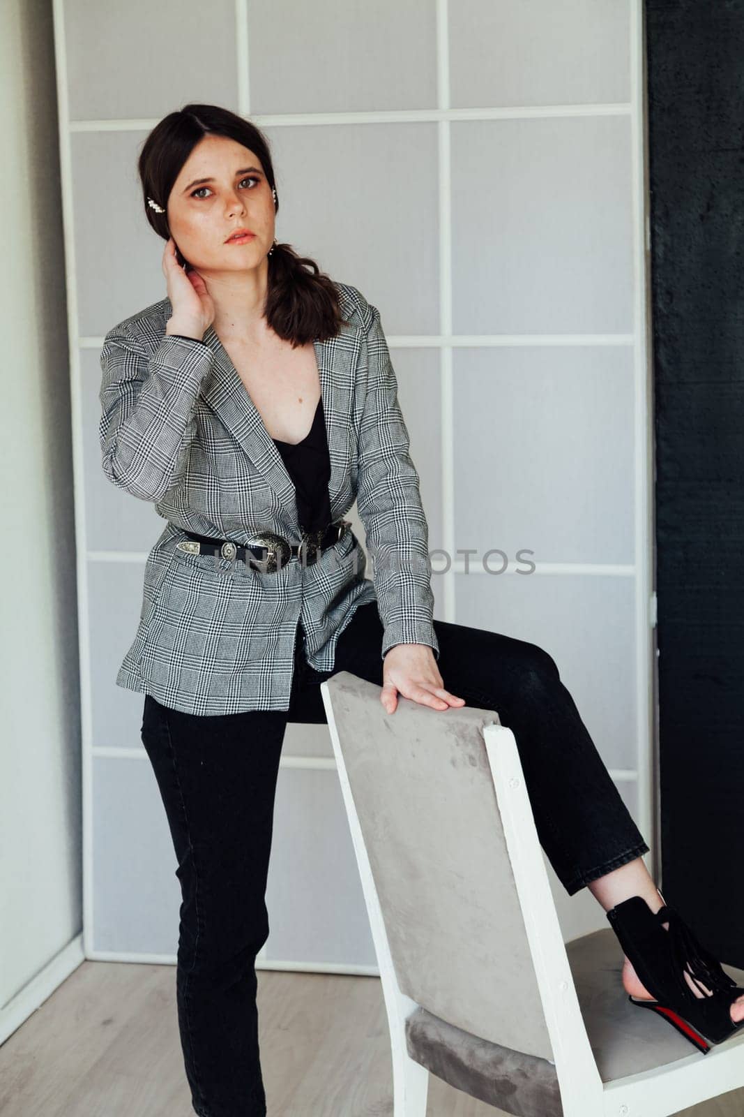 Fashionable woman posing in bright room in studio