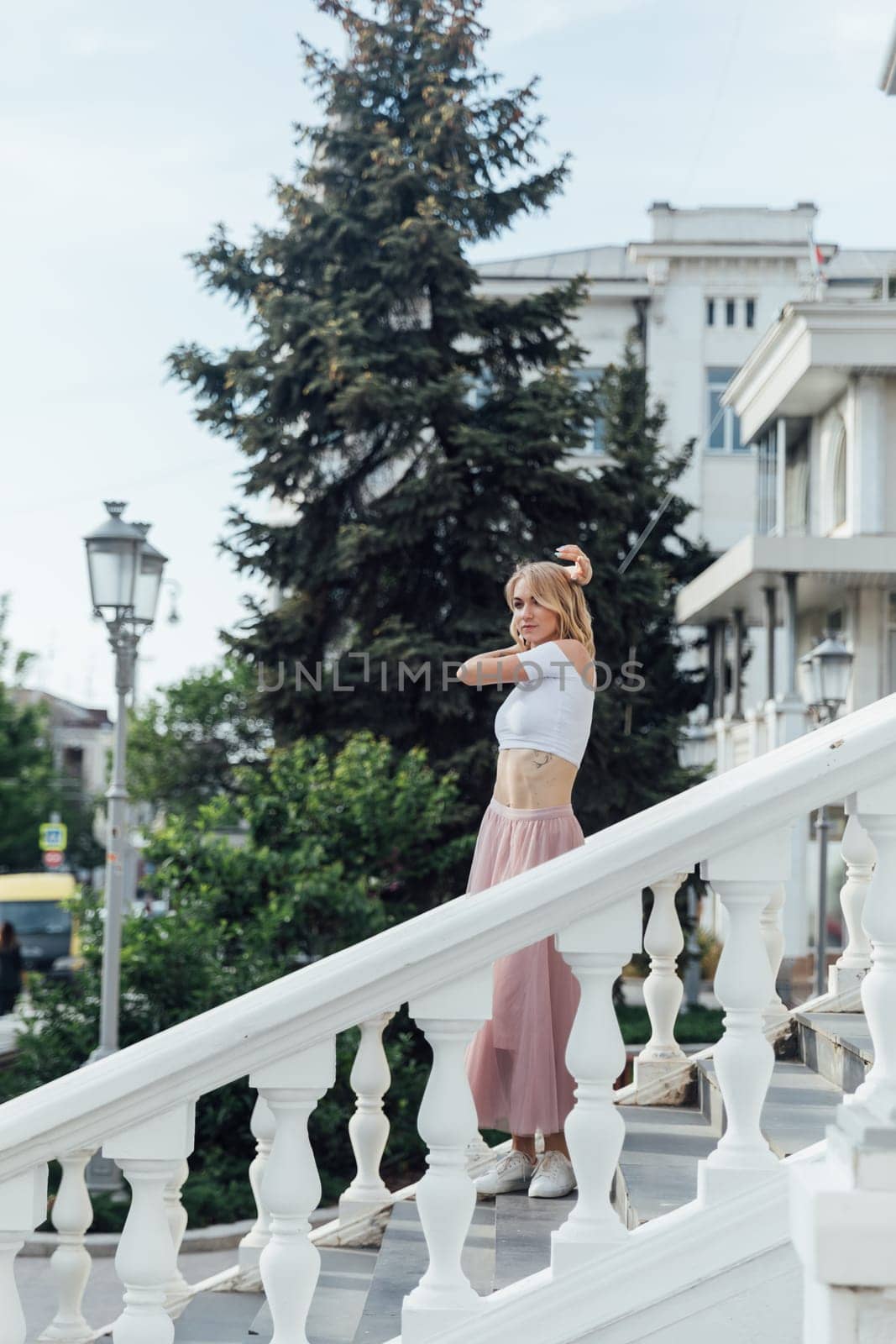 Slender blonde on the street near the railing by Simakov