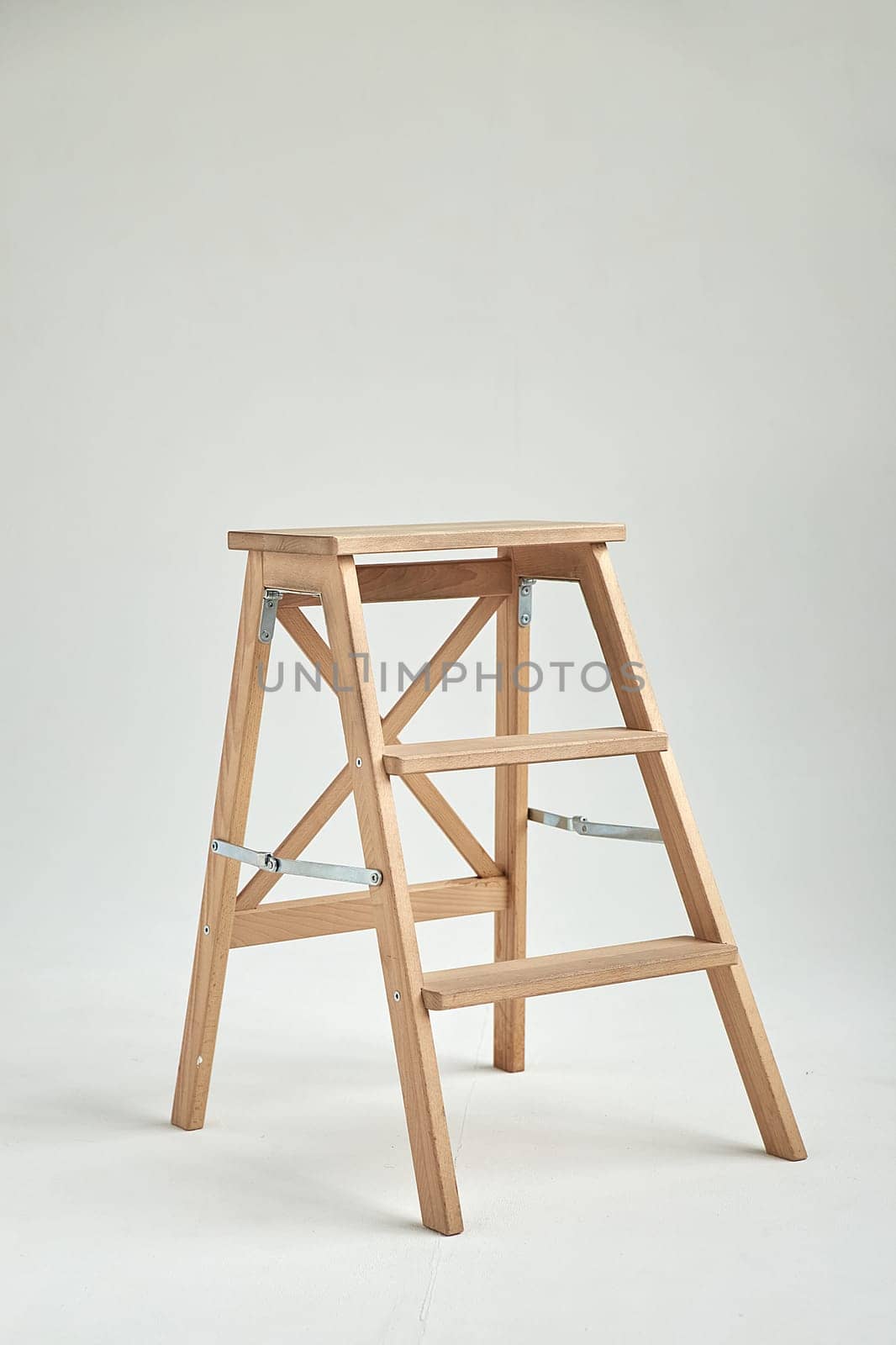 Wooden ladder in empty white room. modern furniture on studio cyclorama