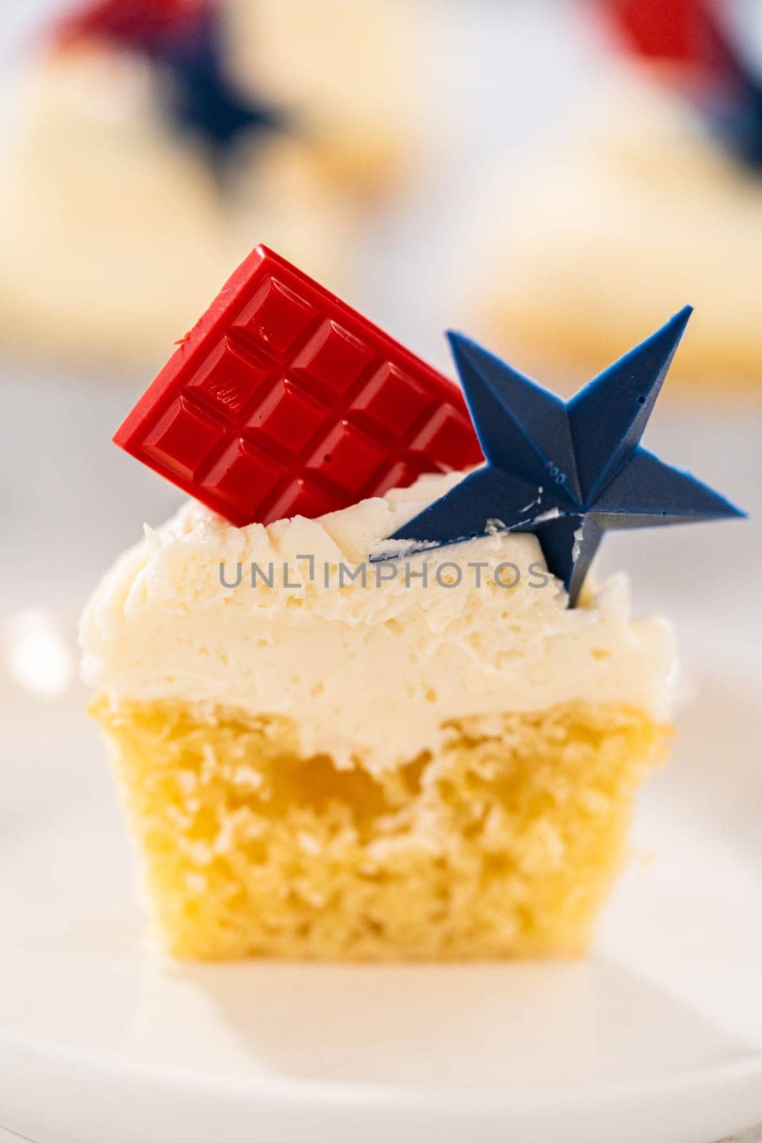Sliced lemon cupcakes with lemon buttercream frosting, and decorated with patriotic blue chocolate star and red mini chocolate.